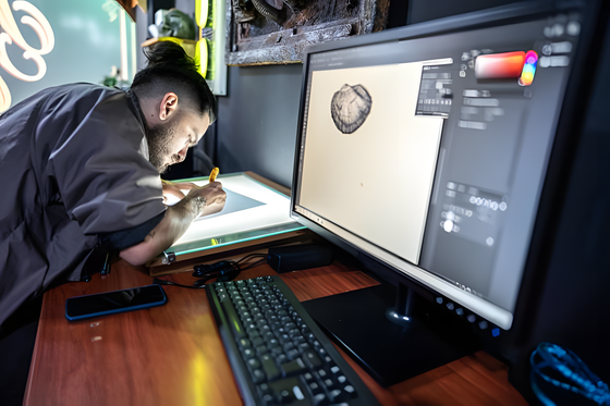 Designer sketching artwork beside a monitor